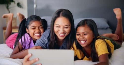 Woman and Children Laughing with Tablet at Home