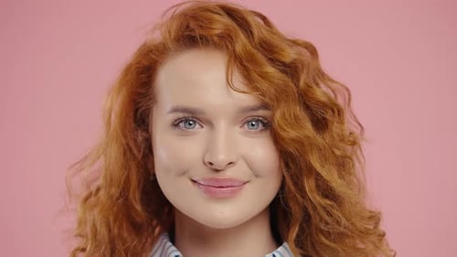 Smiling Woman Posing in Front of Pink Background