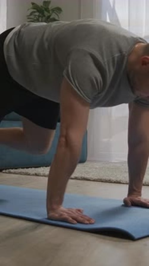 Man Doing Mountain Climber Exercise on Blue Mat