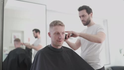 Man Gets Haircut From Bearded Barber Indoors