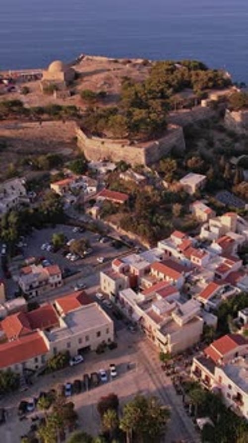 Aerial view of historic fortress and coastal town at sunset