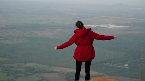 A Woman Walking on a Hill A Woman Standing on a Hill with Her Arms Outstretched Amidst the Untamed