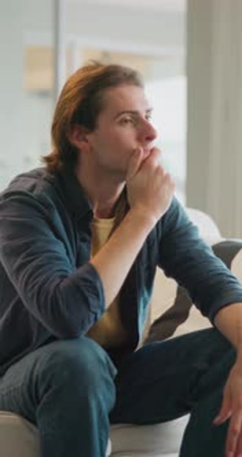Thinking, student and man on sofa with worry for future decision, college application and regret