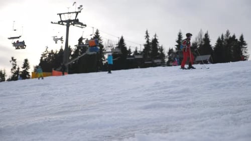Skiers Slides Down on Snowy Hill and Learns to Ride in Ski Resort People Descends on Snow Slope in