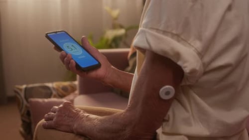 Senior Man Checks Glucose Level on Smartphone