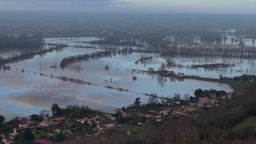 Aerial view of flooded vineyards reflecting the sky, with trees emerging from the water