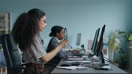 Operator Putting Headset on Head, Taking Notes and Consulting Online Client
