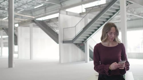 Female Property Owner Using Smart Phone in Empty Warehouse Adult