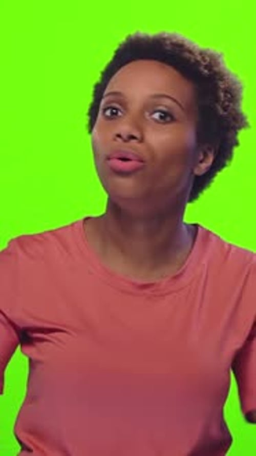 Femme surprise écoutant attentivement sur fond vert vif