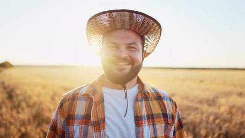 Portrait Young Adult Caucasian Man Farmer in Straw Hat Stands in Rural Wheat Field in Outdoors