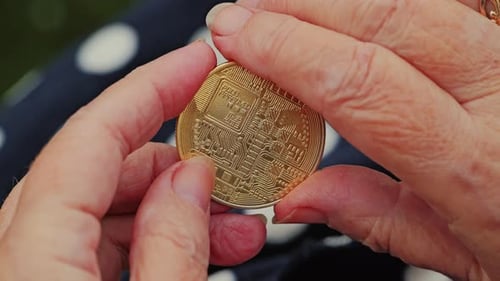 Elderly Woman Examines Bitcoin Coin in Hands During Outdoor Moment Close Up
