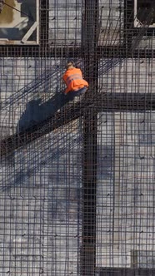 Vertical Video Construction Site With Workers Completing Floor Preparations and Installing Framework