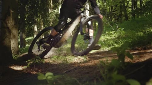 Amazing shot of a biker with MTB E-bike biking down the hill in the forest. Extreme riders.
