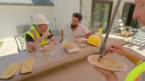 Trabalhadores da construção civil fazendo uma pausa para desfrutar de um almoço satisfatório juntos, compartilhando bons espíritos e risadas