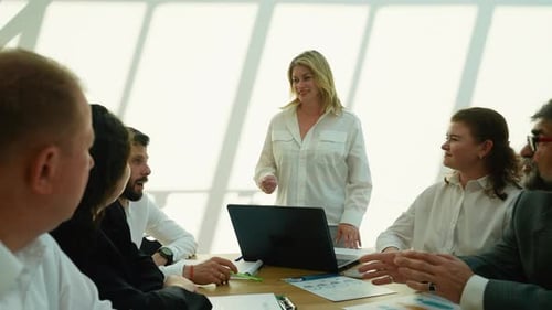 Businesswoman Giving a Presentation to Colleagues in a Modern Office Meeting Room