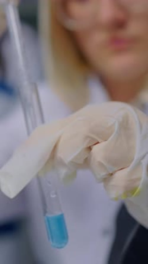 Adult Woman Holding Test Tube in Scientific Laboratory