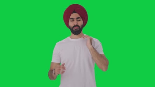 Sick Sikh Indian man suffering from neck pain Green screen