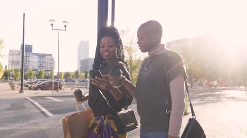 Smiling Women Friends With Coffee Walking In Sunny City Slow Motion
