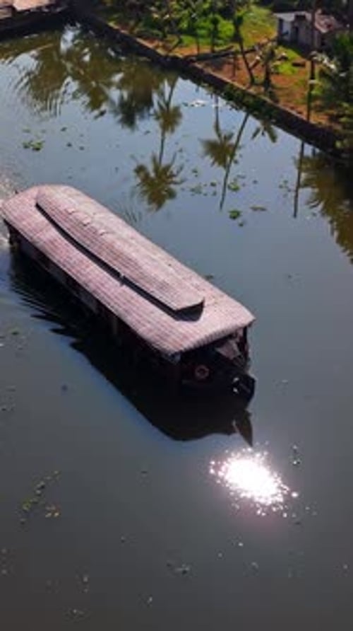 Drone vertical filmé devant une péniche dans les backwaters du Kerala, en Inde