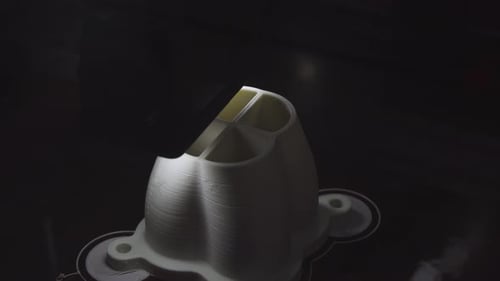Impresora 3D que crea un objeto de plástico blanco capa por capa