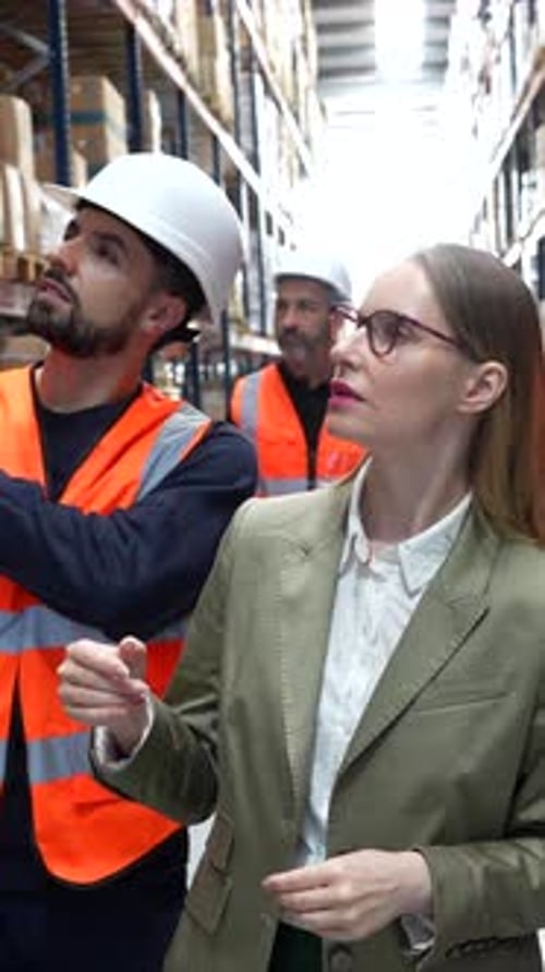 Warehouse Manager Showing Inventory to a Female Supervisor