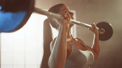 Athletic Beautiful Woman Does Overhead Deadlift with a Barbell in the Gym. Gorgeous Female Professi