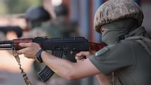 Soldier Aiming Assault Rifle in Outdoor Setting