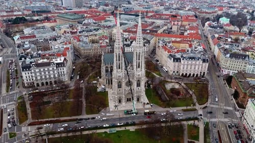 Drone aérien à angle moyen survolant la cathédrale votivkirche de Vienne avec des bâtiments au soleil