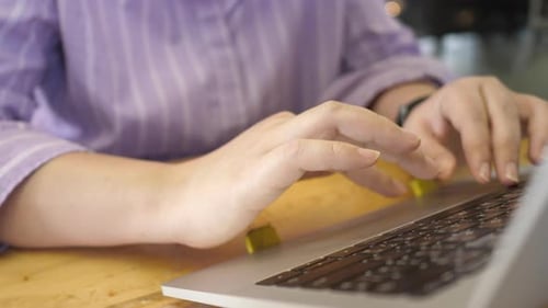 Young adult woman working on laptop computer in cafe