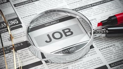 Job Search Concept with Magnifying Glass on Newspaper Classifieds