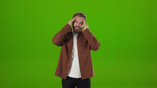 Stressed Man Feeling Strong Headache Over Green Background