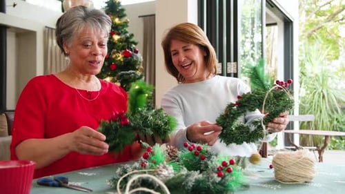 Women Crafting Festive Christmas Wreaths at Home