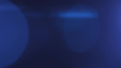 Abstract Overlay Transition of Blue Light Projector Lens Flare Flashes on Dark Background Anamorphic