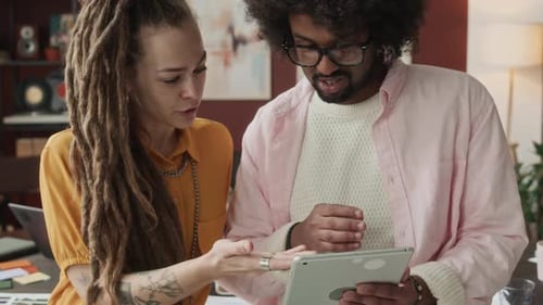 Colleagues Collaborate Using a Tablet Indoors