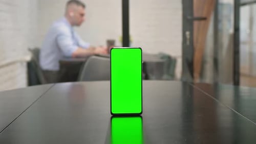 Phone with Green Screen on Desk