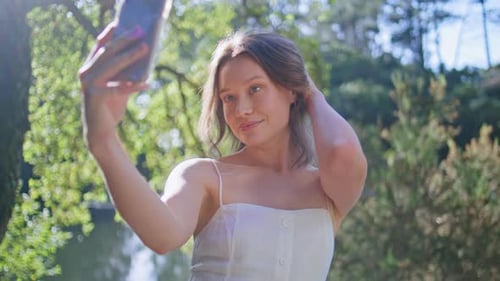 Flirting Girl Making Selfie Cellphone Posing at Lake Shore in Dress Closeup
