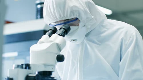 Close-up of the Engineer/ Technician/ Scientist Checking Component under the Microscope. He Wears S