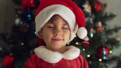 Adorable Child Smiling in Santa Suit Near Christmas Tree
