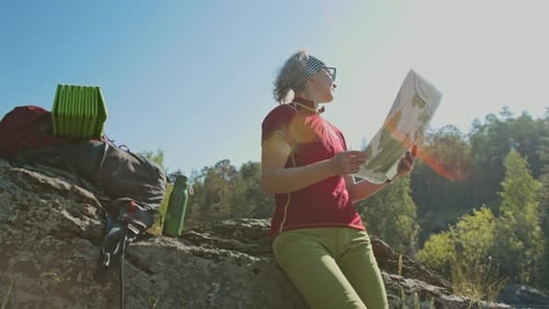Woman Hiker Reading Map in Forest