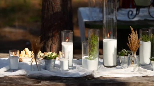 Wedding Party Banquet Outdoors in Forest Dining Table Decorated in Boho Style with Candles White