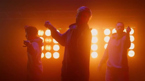 Professional hiphop band performing street style dance moves in night club with spotlights