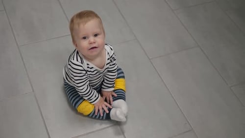 Baby Sits on Floor Looking at Camera