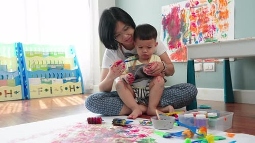 Woman and Child Painting Together on Floor