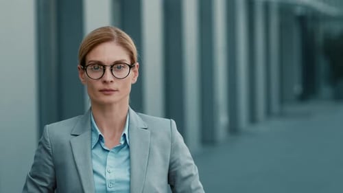 Businesswoman With Glasses Standing Outside a Modern Office Building