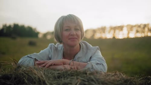 Farmer Lying on Piled Hay with Warm Reflective Smile in Golden Light