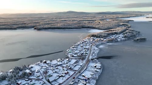Aerial view of a snowy village on a peninsula surrounded by frozen lakeV