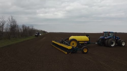 Blue tractor OA working on the field in Ukraine