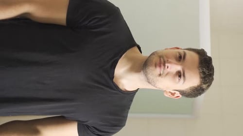 Man Sprays Cologne in Bright Bathroom