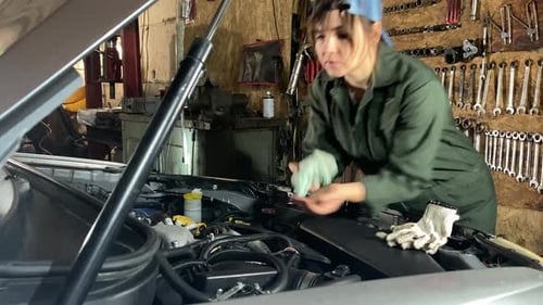 Young Female Mechanic Completes Car Repair and Inspection