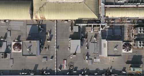 Industrial building rooftops with vents and pipes lined across, Top down view